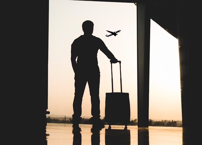 silhouette of man holding luggage inside airport